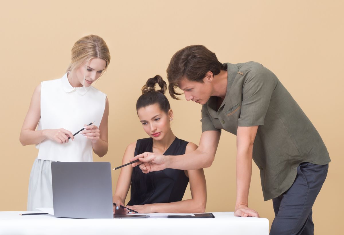 A small team collaborating around a laptop